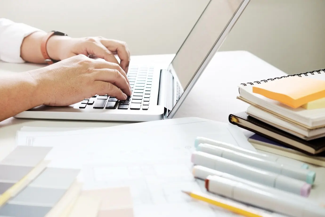 Grafikdesign sowie Farbmuster und Stifte auf einem Schreibtisch. Architekturzeichnung mit Arbeitswerkzeugen und Zubehör.